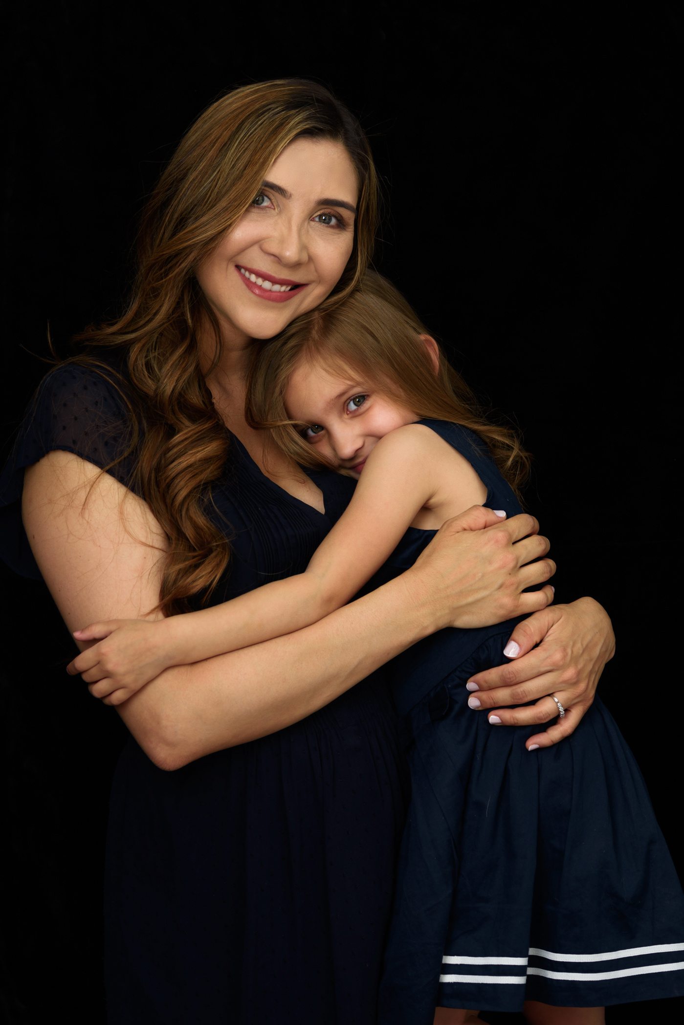 Fine-art Mummy and Me portrait. Mother photographed with her daughter on a black velvet background on the occasion of Mother's Day. We created heirloom portraits as Wall Art to remind the family everyday of their love for each other.