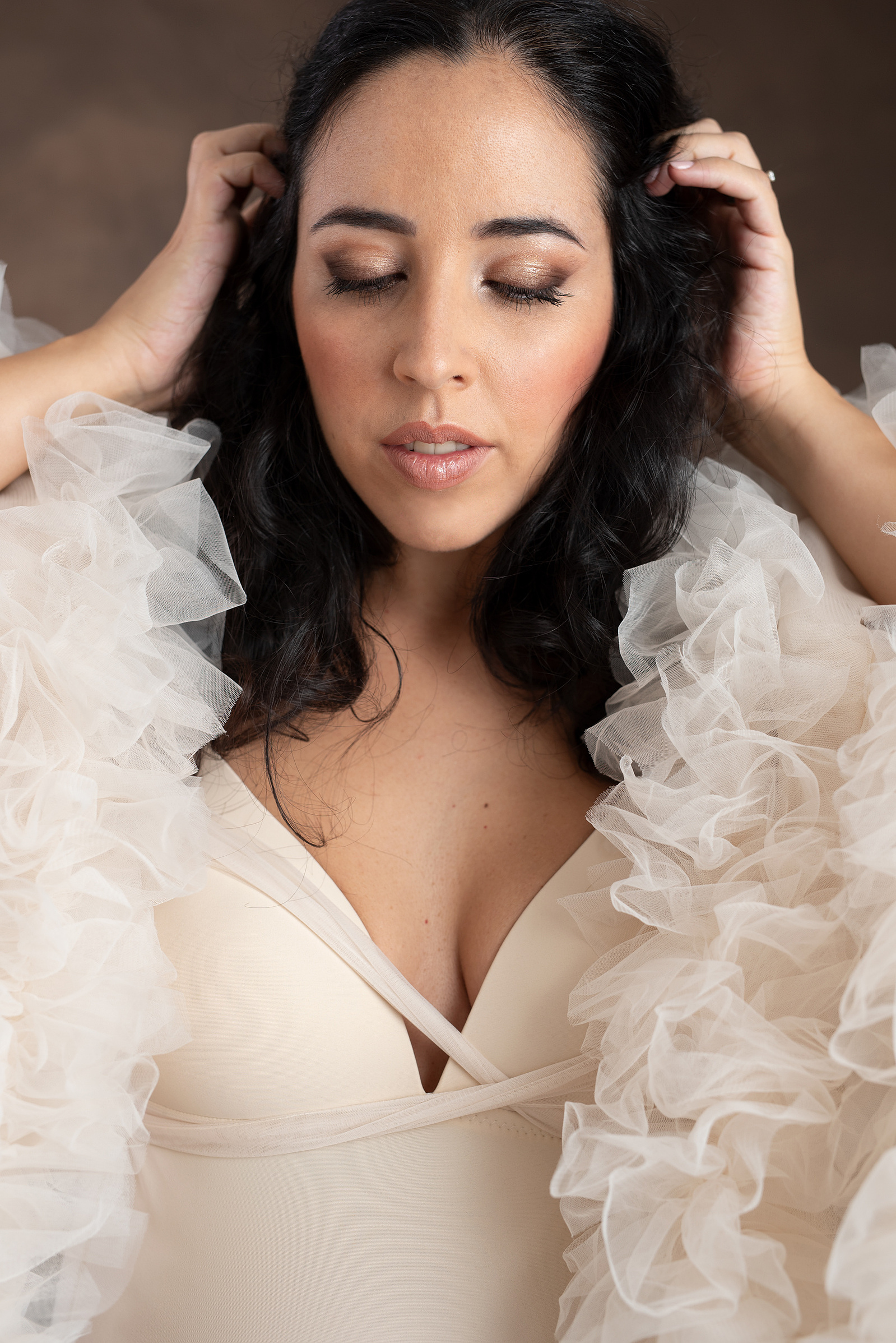 Fine-Art Maternity Portrait Photographer based in Chêne-Bougeries, Geneva. Close-up of Natalia, showing off her makeup, wearing a K.H. Fashion house cream bodysuit with ruffled jacket. Makeup was done by Christine Poitier. @cpothiermakeup
