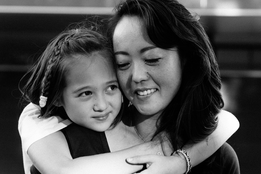 A young girl hugs her mother. Black and white portrait shot for a Mummy and Me photoshoot, available at https://www.helenputsman.com/