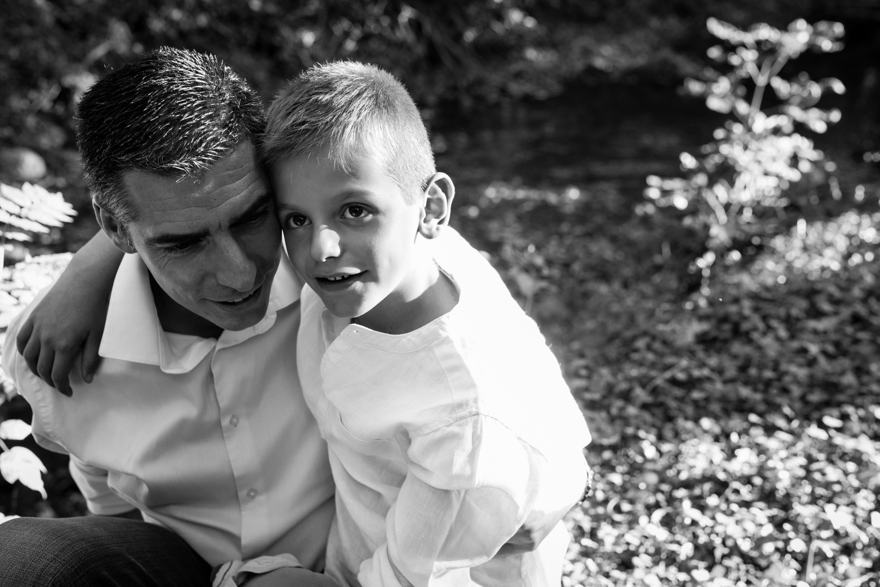 Father and son, natural black & white lifestyle portrait taken at the Seymaz behind my home-studio in Chêne-Bougeries, Geneva.