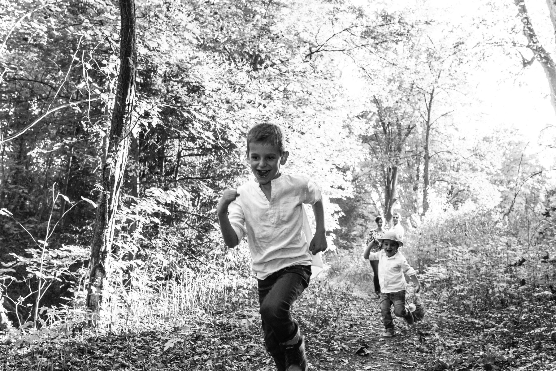 Two brother run in the wild, taken during a family lifestyle portrait portrait taken at the Seymaz behind my home-studio in Chêne-Bougeries, Geneva.