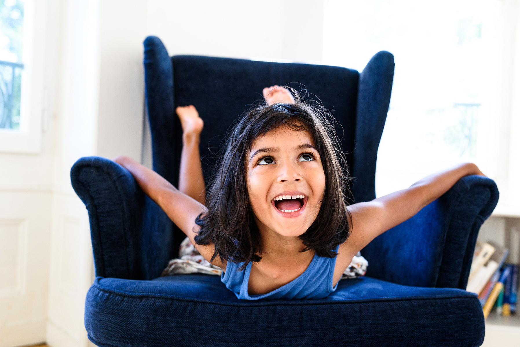 Electric portrait of a young girl showing her energy and enthusiasm for life, captured during a family lifestyle photo session, shot in Geneva.