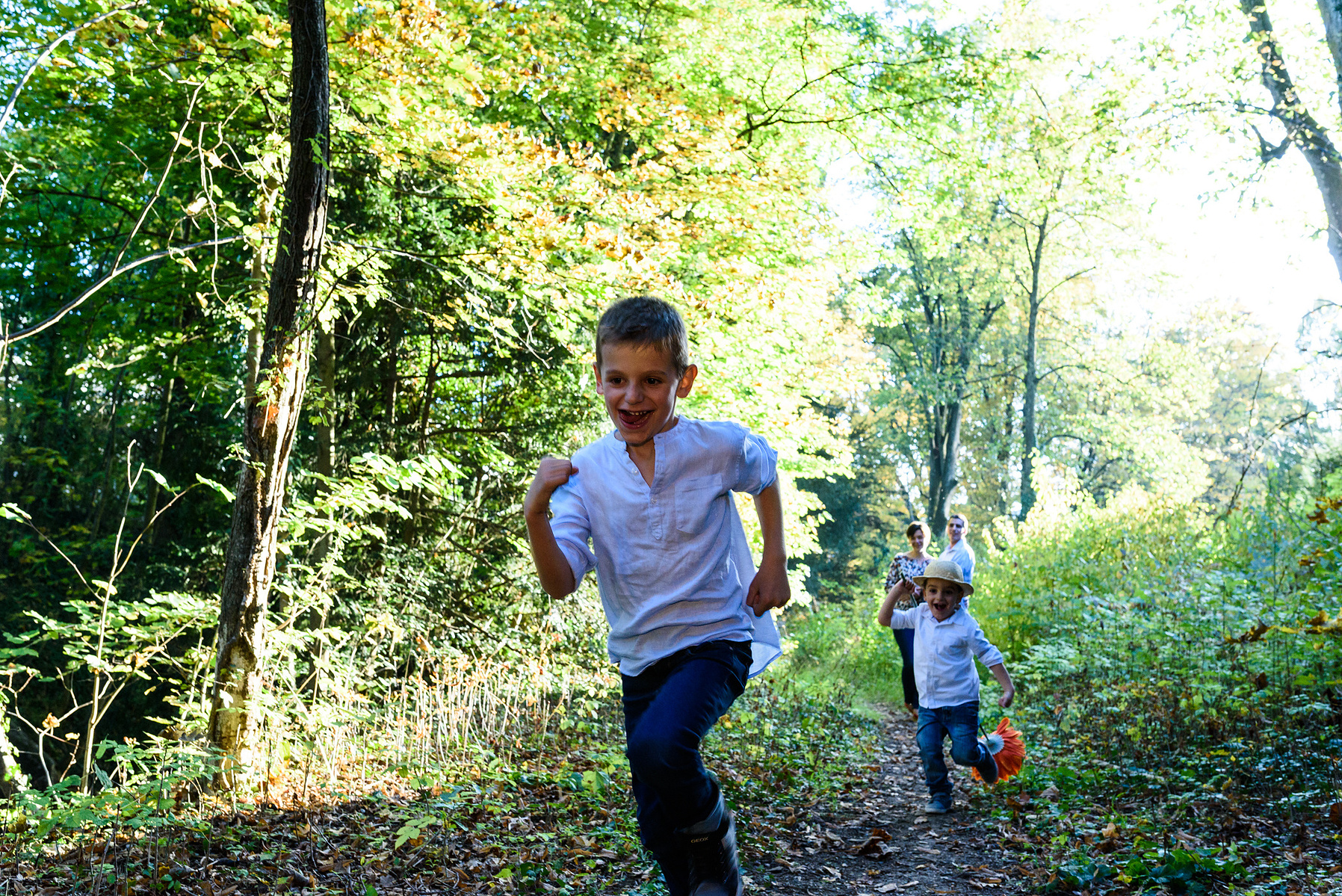 Two brother run in the wild, taken during a family lifestyle portrait portrait taken at the Seymaz behind my home-studio in Chêne-Bougeries, Geneva.