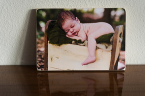 A newborn baby photographed on a vintage wooden bed in nature and printed onto a Photoblock. They are great for people who love nature and wood.