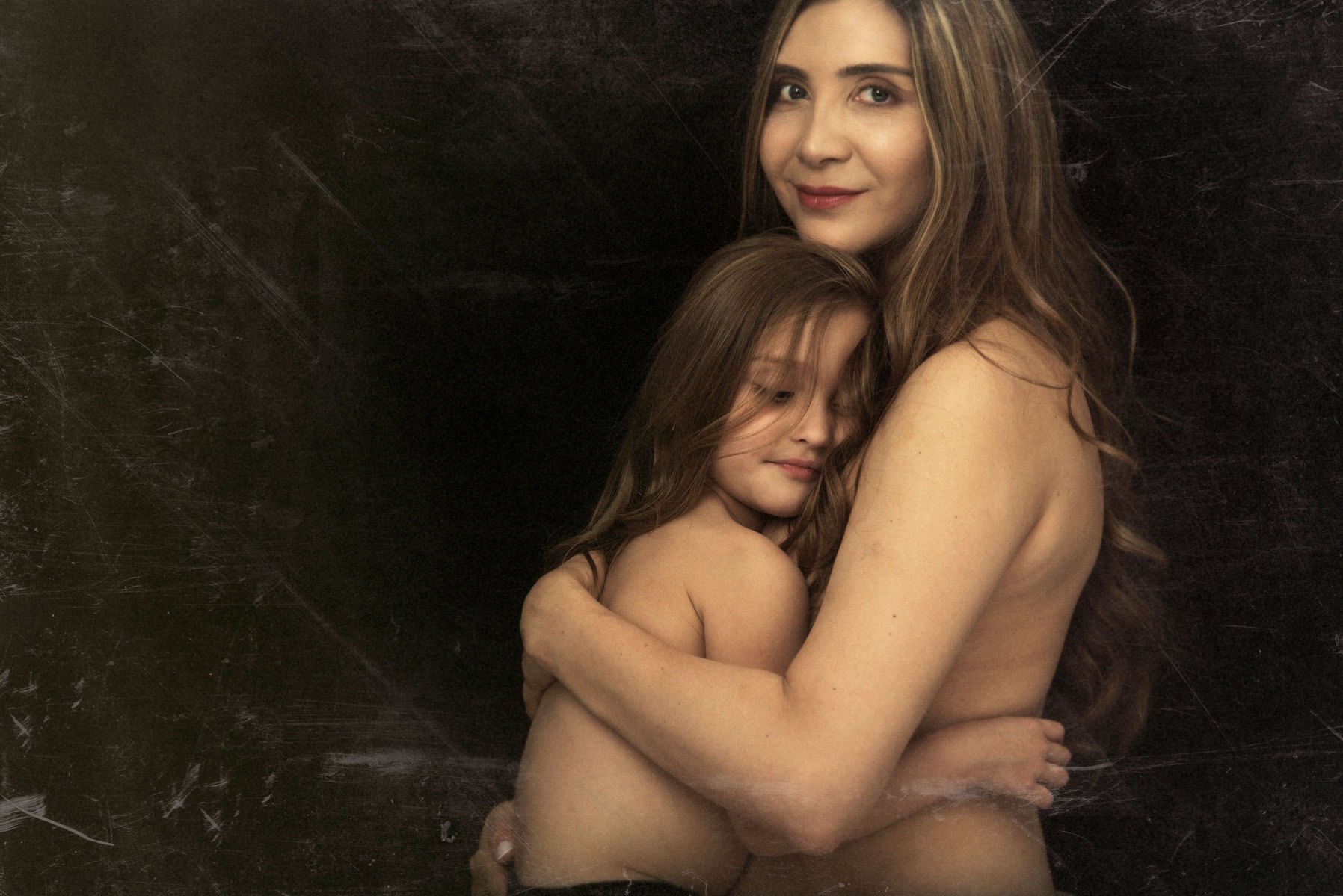 Fine-art Mummy and Me portrait. Mother photographed with her daughter, they embrace, skin-skin, smiling, their hair blending together. We created these heirloom portraits as Wall Art to remind the family for years to come of their love for each other.