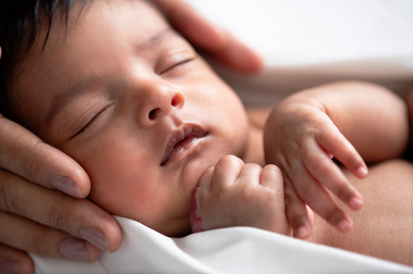 Words of thanks to me as a portrait photographer from the mother who is holding her newborn baby's face in her hands for a natural lifestyle airy photo shoot in Geneva.
