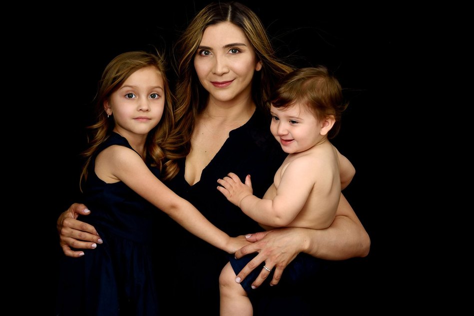 Fine-art Mummy and Me portrait. Mother photographed with her daughter and son on a black velvet background on the occasion of Mother's Day. We created heirloom portraits as Wall Art to remind the family everyday of their love for each other.
