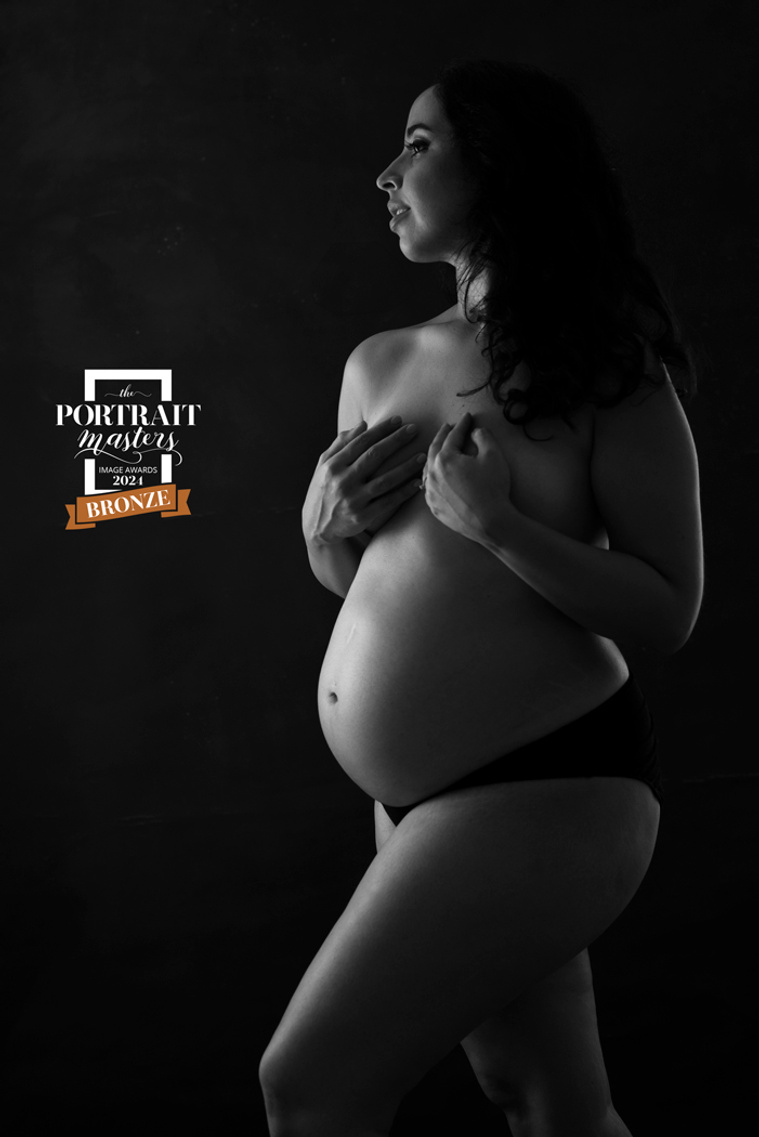 Bronze Merit in the Maternity section of the Portrait Masters 2024 Image Awards. Black and white pregnancy silhouette showing the beautiful curves of pregnancy, shot in my studio in Chêne-Bougeries, Geneva.