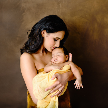Newborn photography portrait of mother holding her newborn baby. Studio in Chêne-Bougeries.