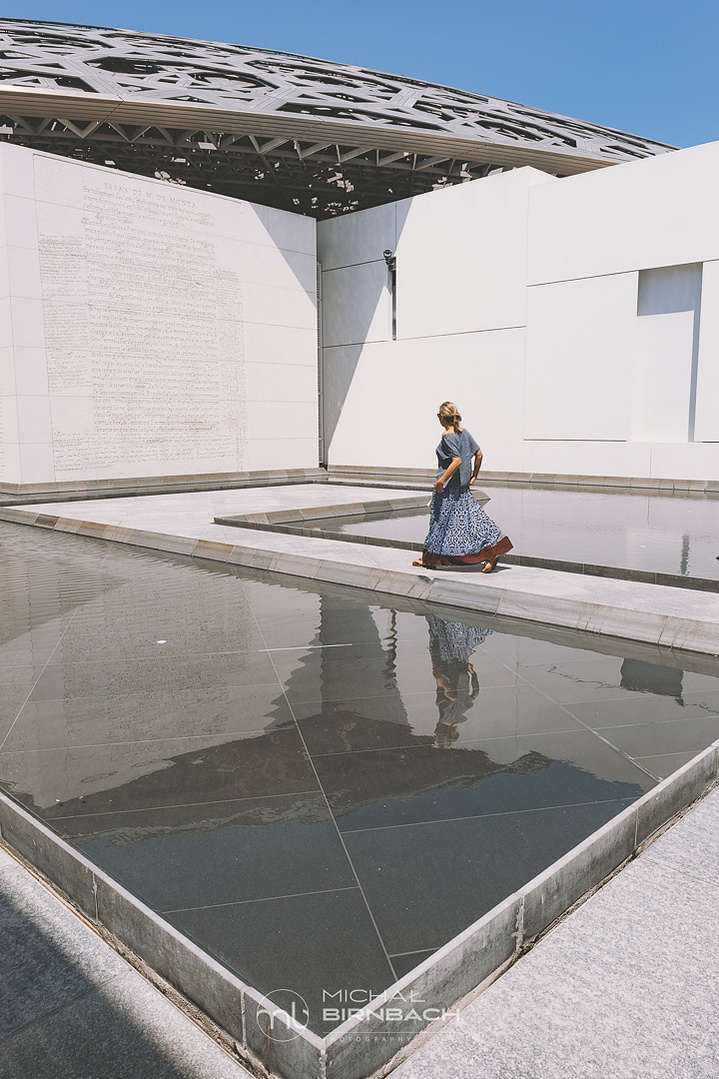 A woman walking in the Louvre Abu Dhabi museum. Travel photography. Editorial.