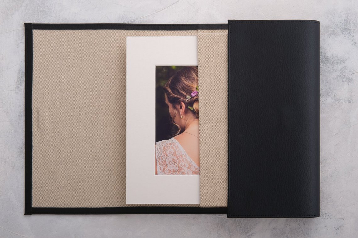 Pochette ouverte contenant une photo de mariée encadrée avec un passe-partout.