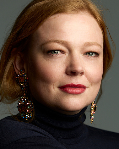 Sarah Snook in a polo neck and large earrings 