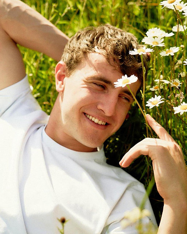 Paul Mescal lying down in a field of flowers