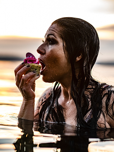 Girl eating cupcake while standing in cold water.