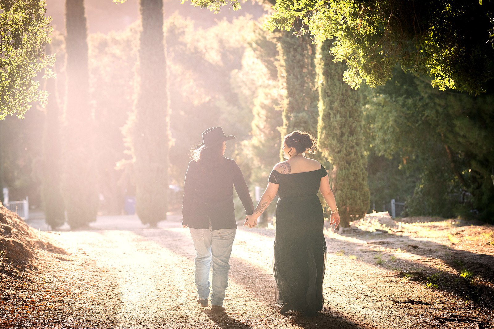 Two brides walking into a hazy forested area at an LGBTQ wedding on the Pala Indian Reservation outside San Diego, California