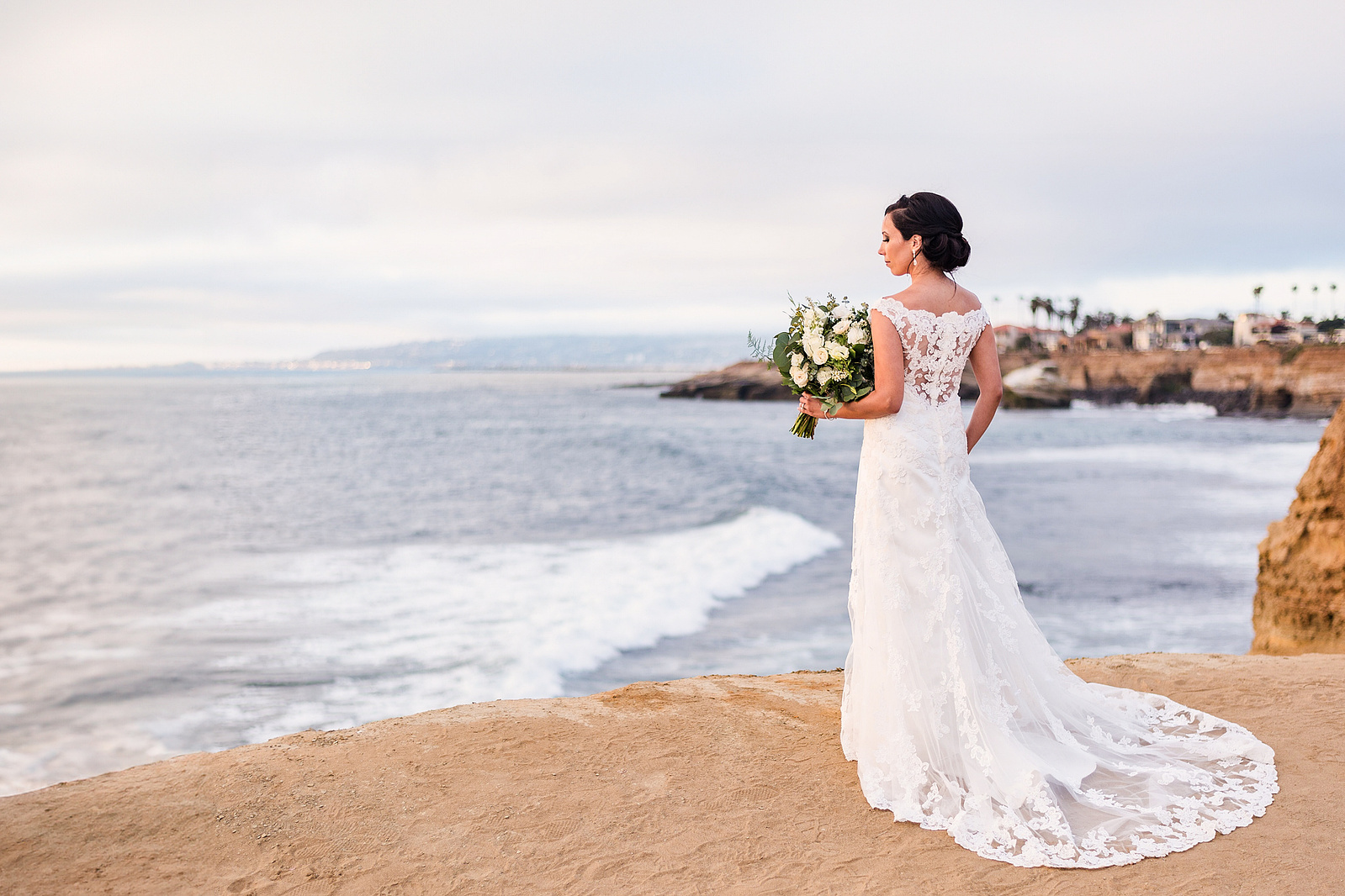 Editorial bridal photo of bride looking over ocean at Sunset Cliffs in San Diego.