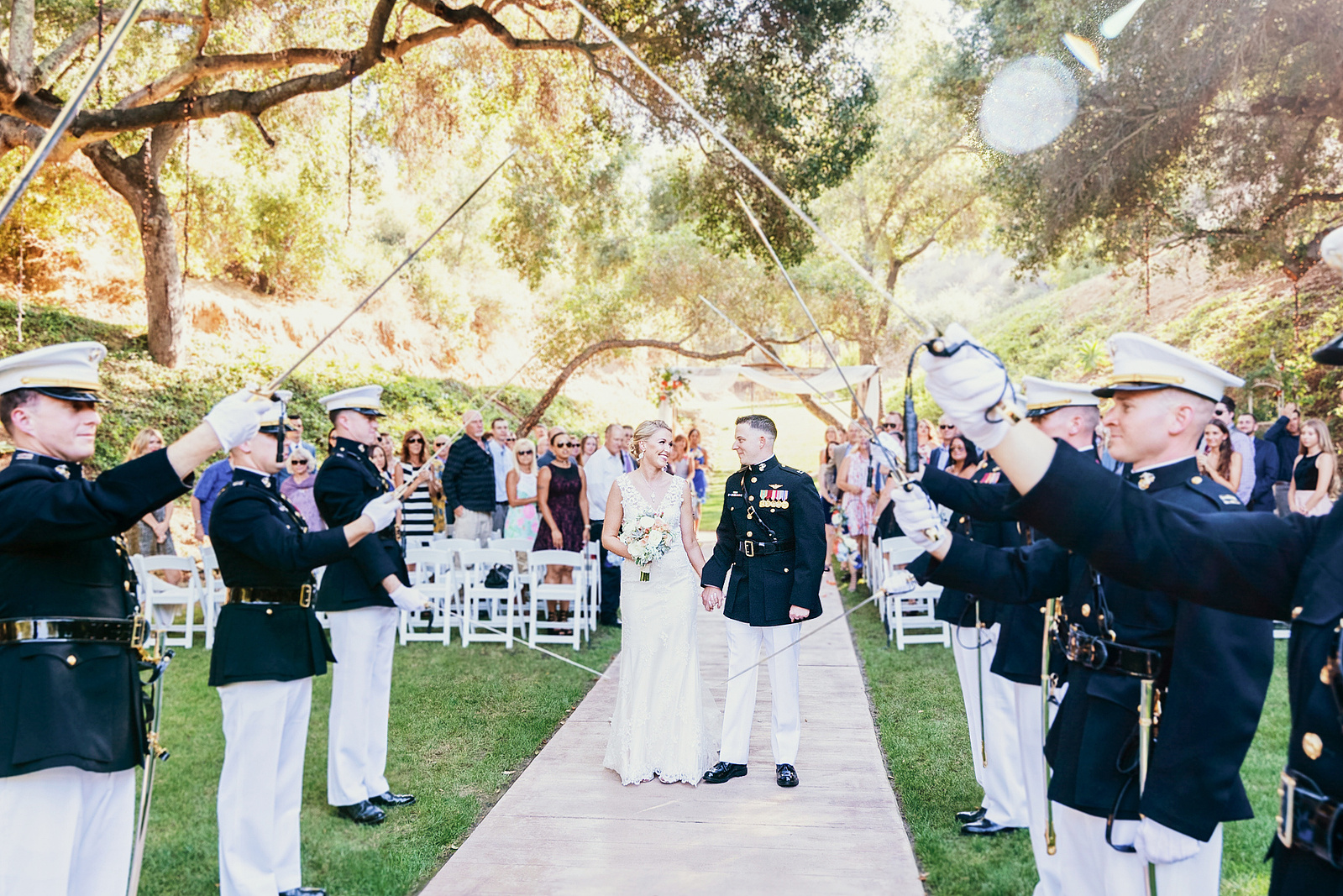 Just married couple after ceremony at a military wedding with Marines saluting them near San Diego, California.