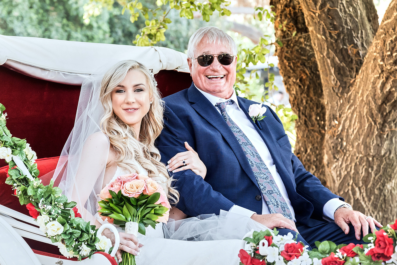 Bride with father on horse drawn carriage entering wedding ceremony outside San Diego, California.