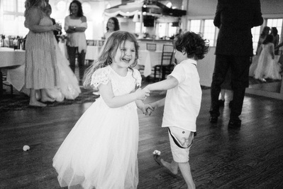 Children dancing at wedding reception in black and white.