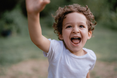 Young boy excitedly running toward camera and laughing.
