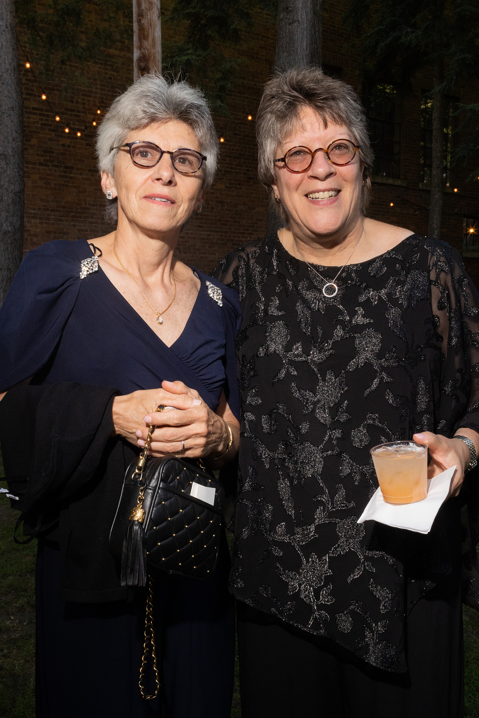 Two wedding guests pose for a picture. Wedding photojournalism at Senate Garage in Kingston, NY.