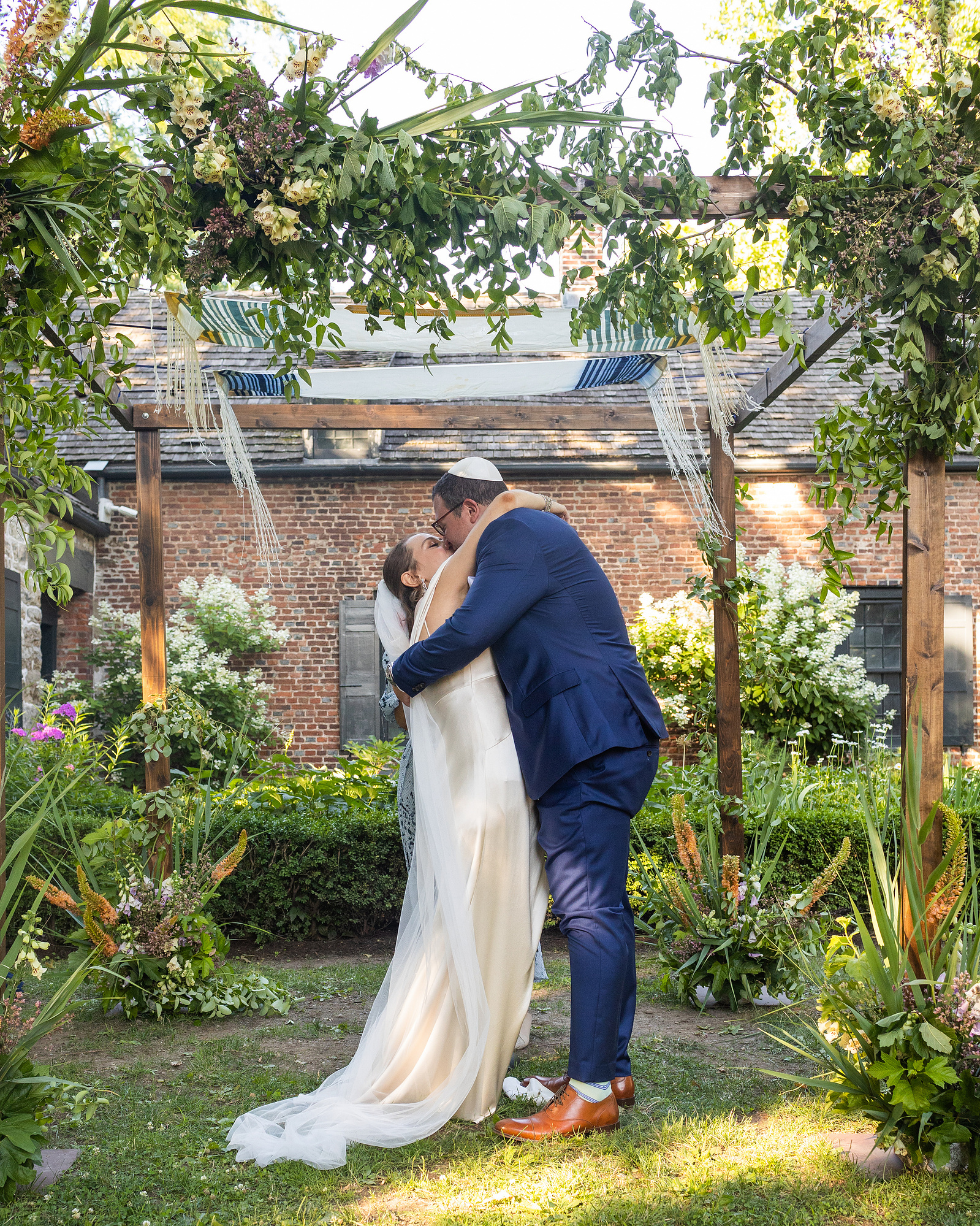 First kiss under the chupa. Wedding photojournalism at Senate Garage in Kingston, NY.