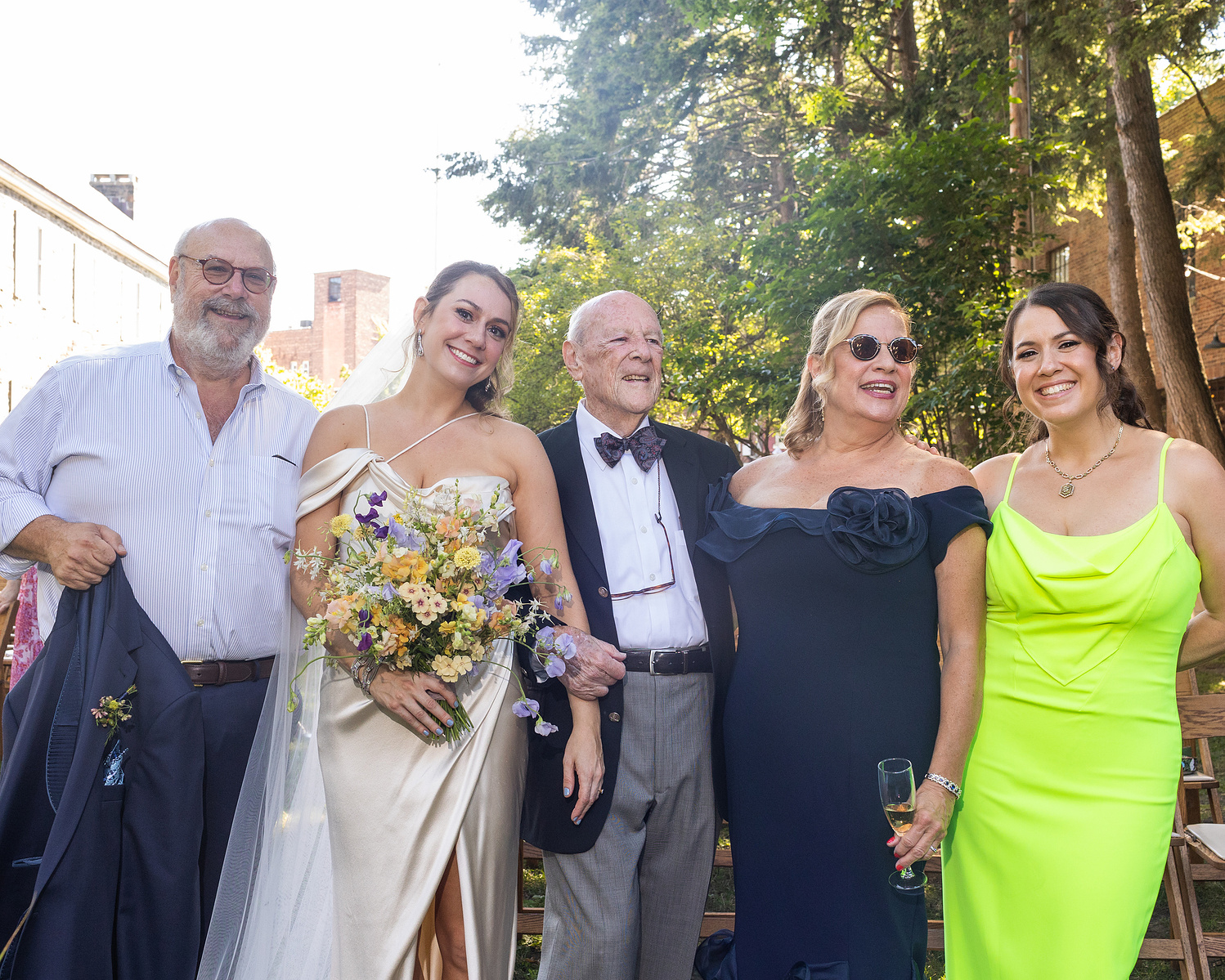 Five people stand together for a family photo. Wedding photojournalism at Senate Garage in Kingston, NY.