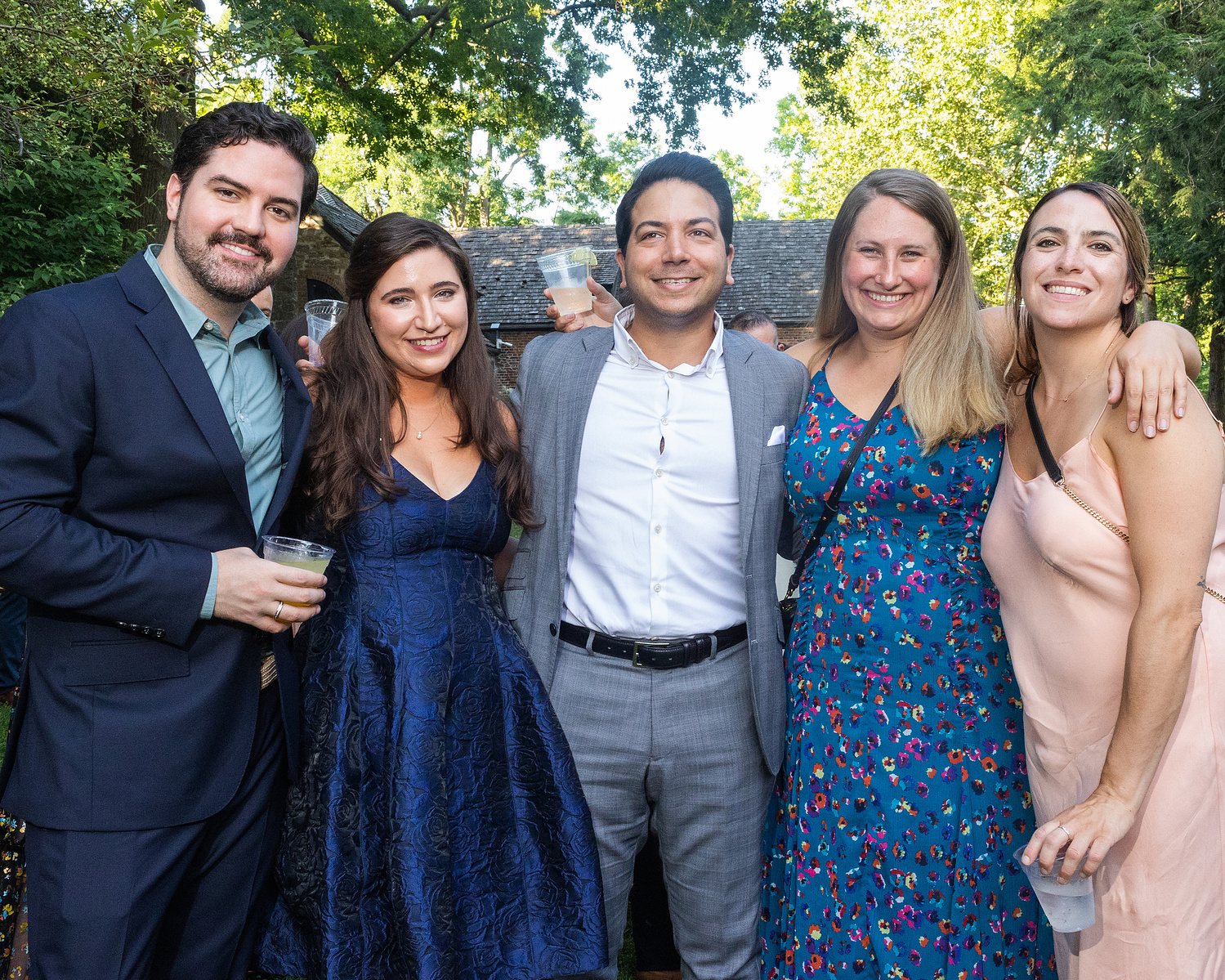Five wedding guests pose for picture at cocktail hour. Wedding photojournalism at Senate Garage in Kingston, NY.