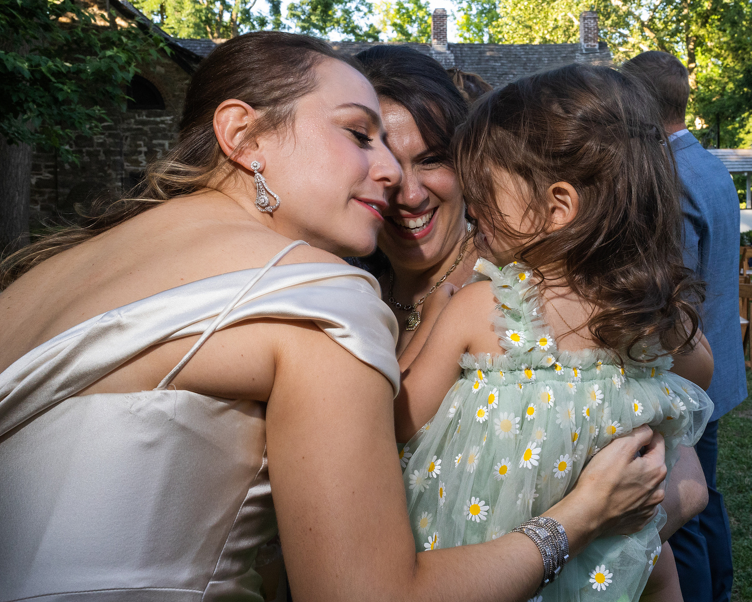 Bride and sister snuggle niece. Wedding photojournalism at Senate Garage in Kingston, NY.