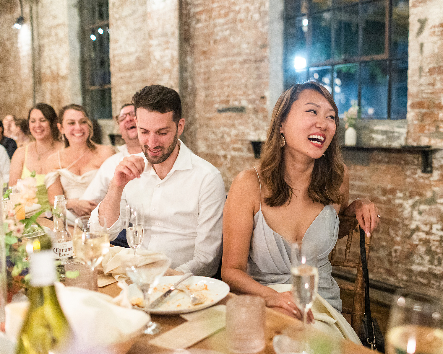 Guests laugh during speech. Wedding photojournalism at Senate Garage in Kingston, NY.