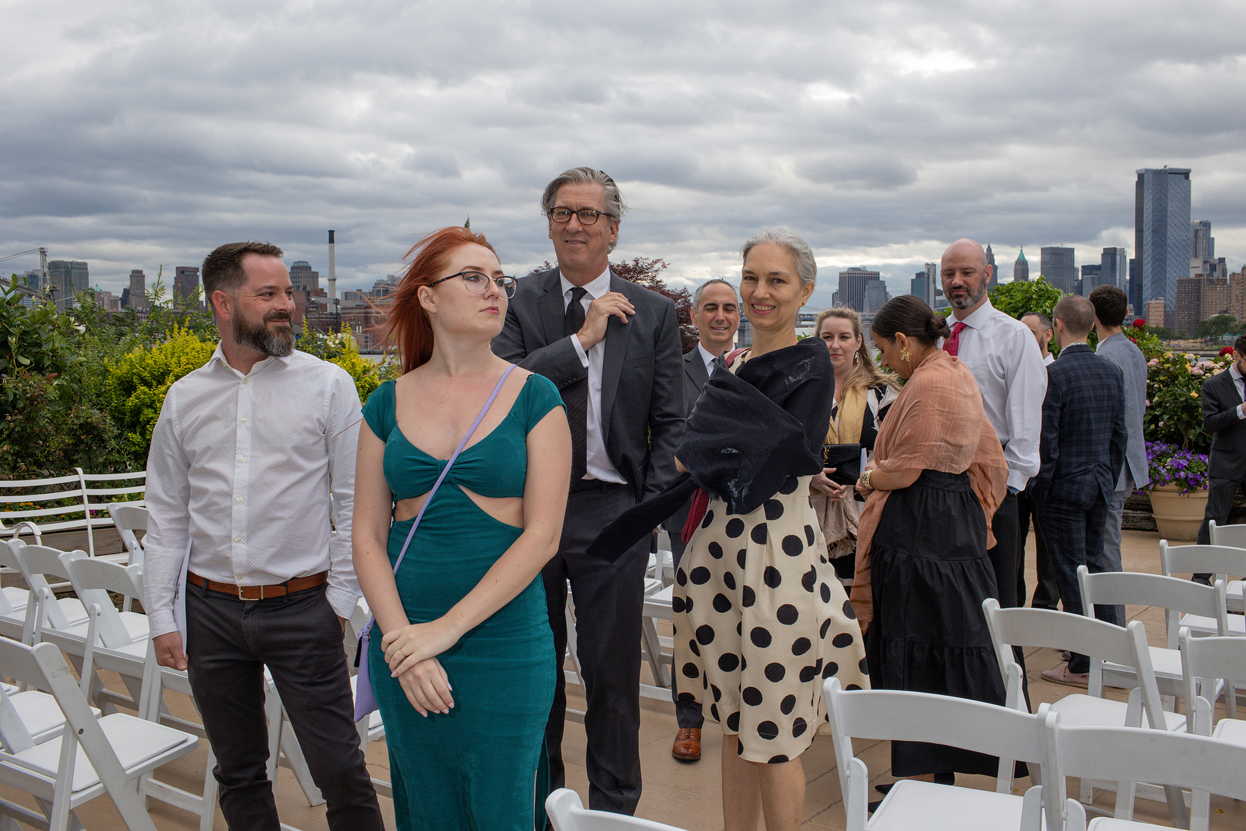 Wedding guests standing at ceremony site. Wedding photojournalism at Giando on the Water in Brooklyn, NY. 