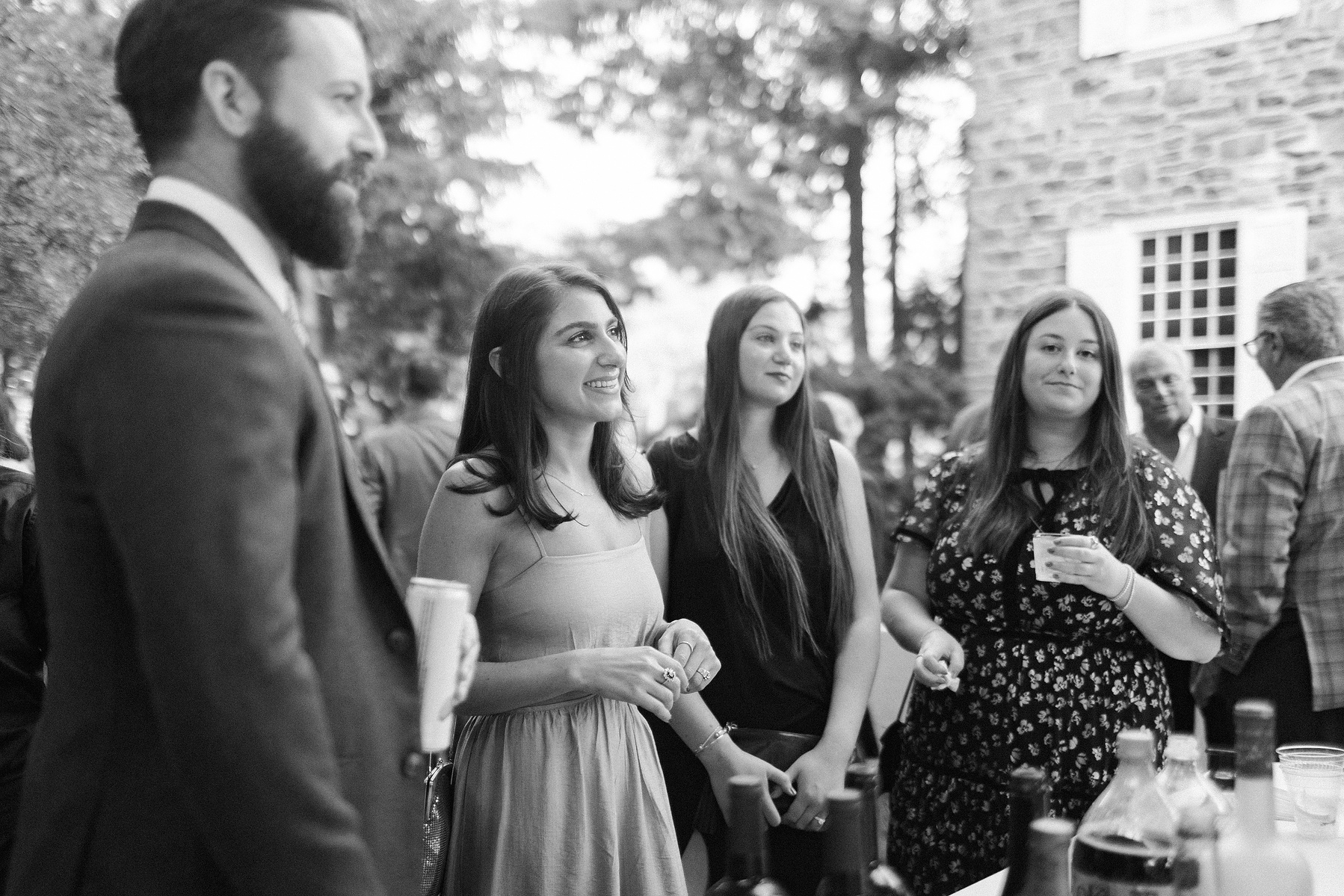 Four wedding guests hanging out at cocktail hour. Wedding photojournalism at Senate Garage in Kingston, NY.