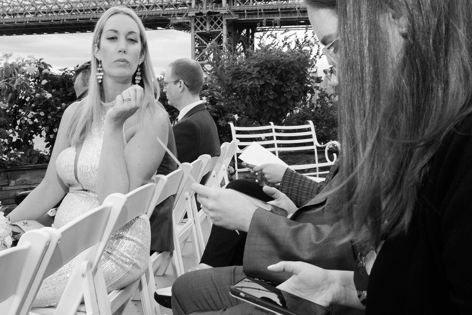 Wedding guest sitting at ceremony site. Wedding photojournalism at Giando on the Water in Brooklyn, NY. 