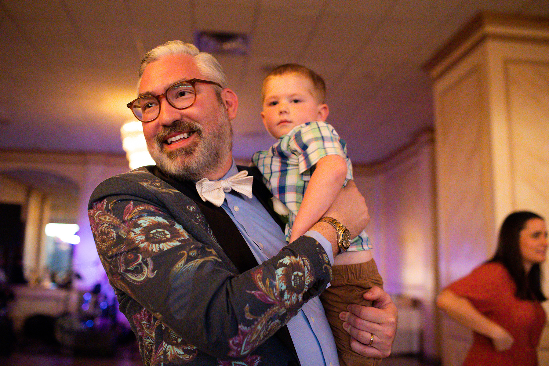 Wedding guest holds baby. Wedding photojournalism at Giando on the Water in Brooklyn, NY. 