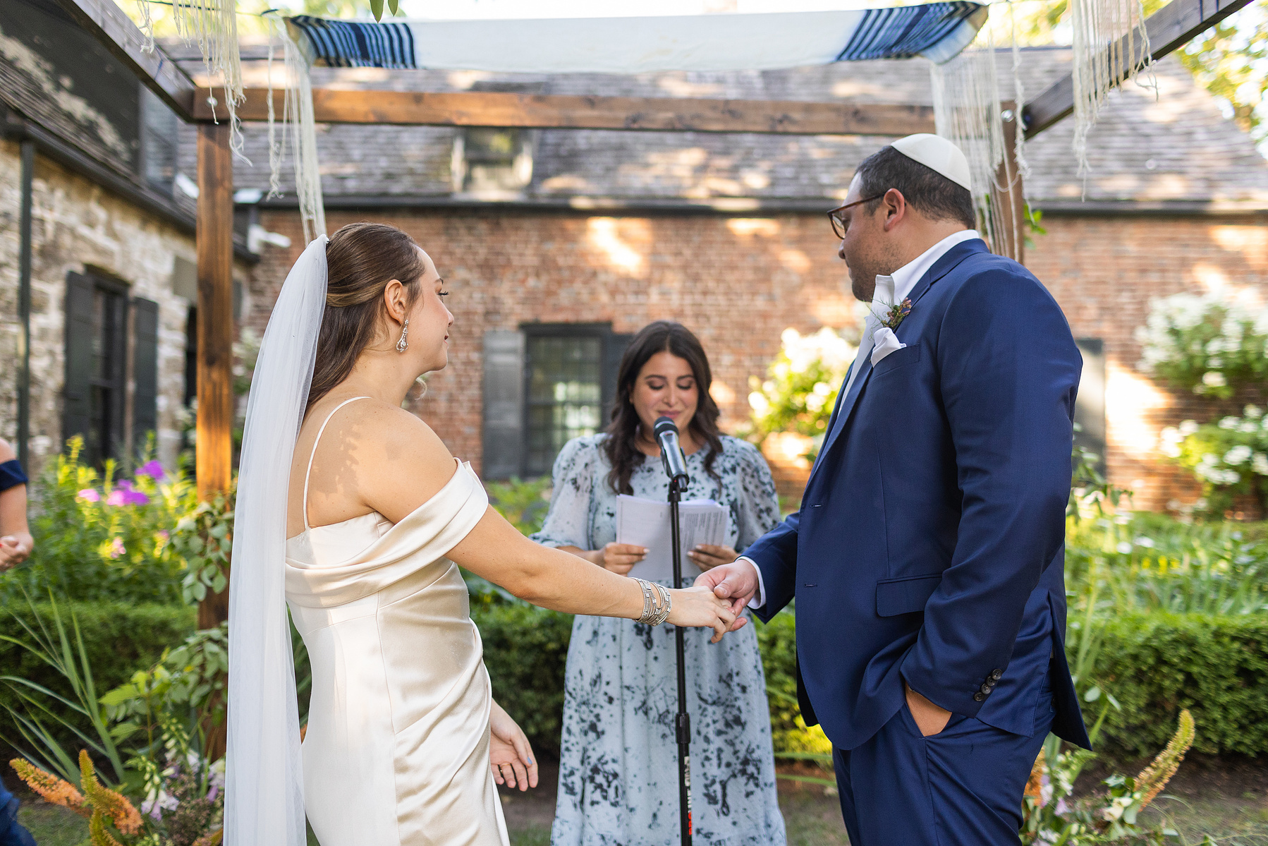 Bride and groom at ceremony holding hands. Wedding photojournalism at Senate Garage in Kingston, NY.