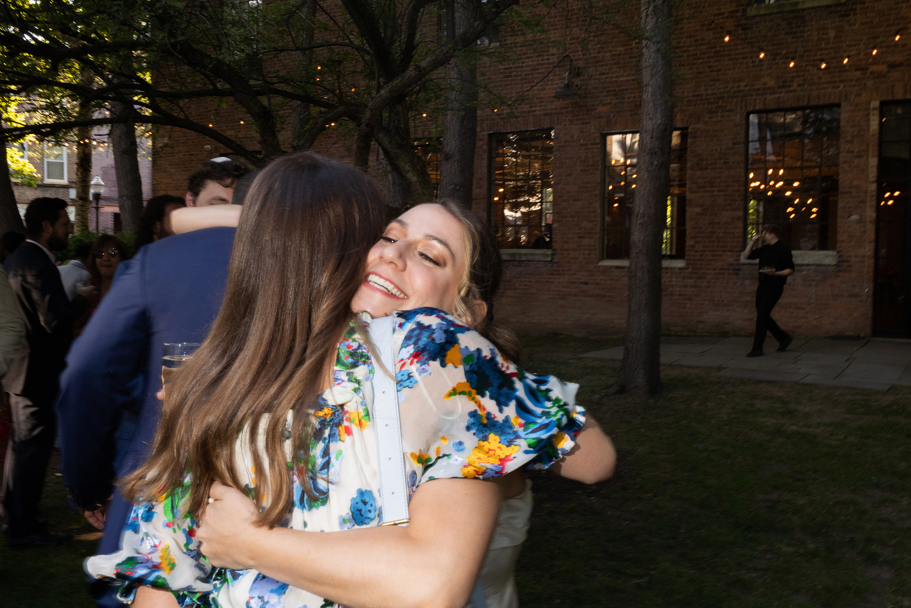 Guest hugs bride. Wedding photojournalism at Senate Garage in Kingston, NY.