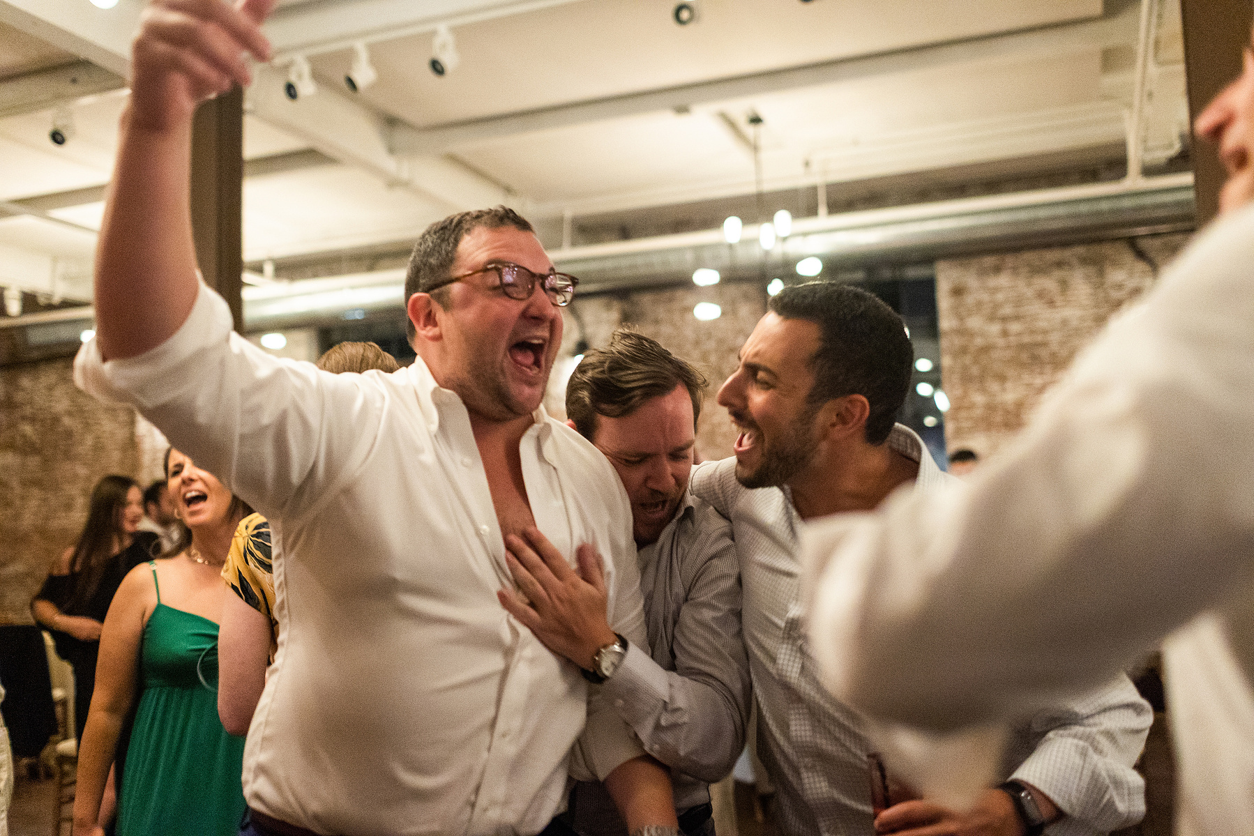 Groom and friend dance. Wedding photojournalism at Senate Garage in Kingston, NY.