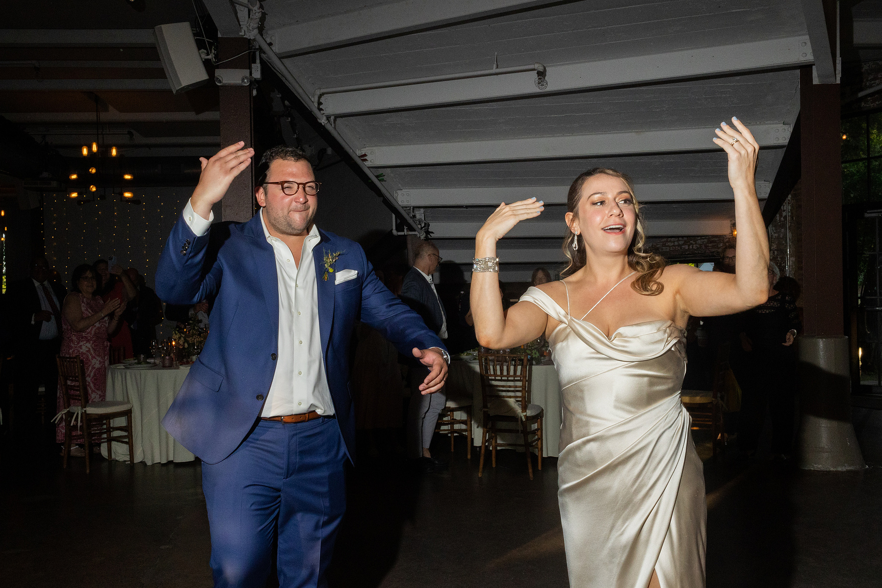 Bride and groom motion everyone to dance floor. Wedding photojournalism at Senate Garage in Kingston, NY.