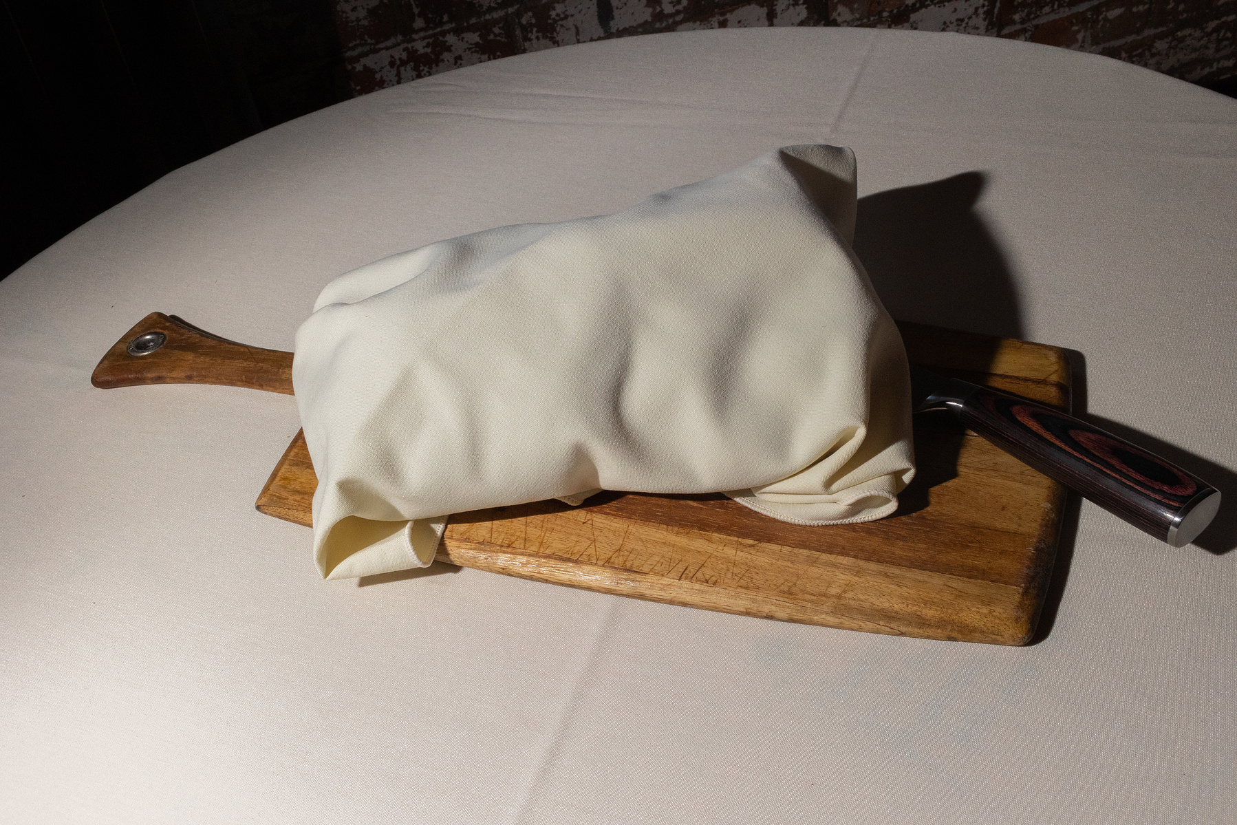 Challah wrapped up in napkin with knife alongside it. Wedding photojournalism at Senate Garage in Kingston, NY.