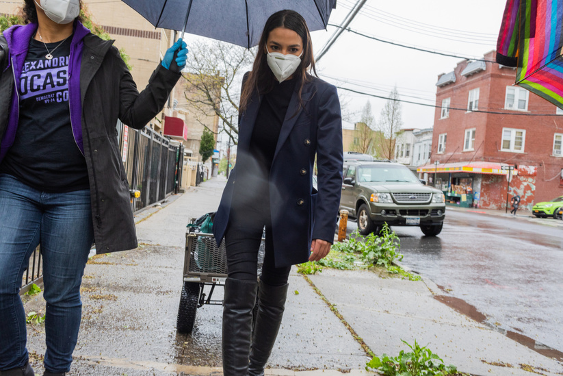 Alexandria Ocasio-Cortez pulls a cart of groceries in the Bronx this past May on one of the many food distributions her campaign organized. Her campaign has delivered 80,000 meals and raised over $1.1M for Covid19 relief.