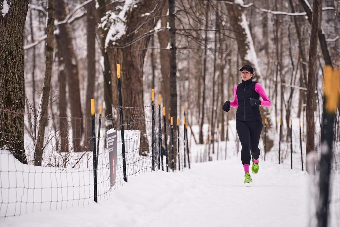 Women running in the snow in trails