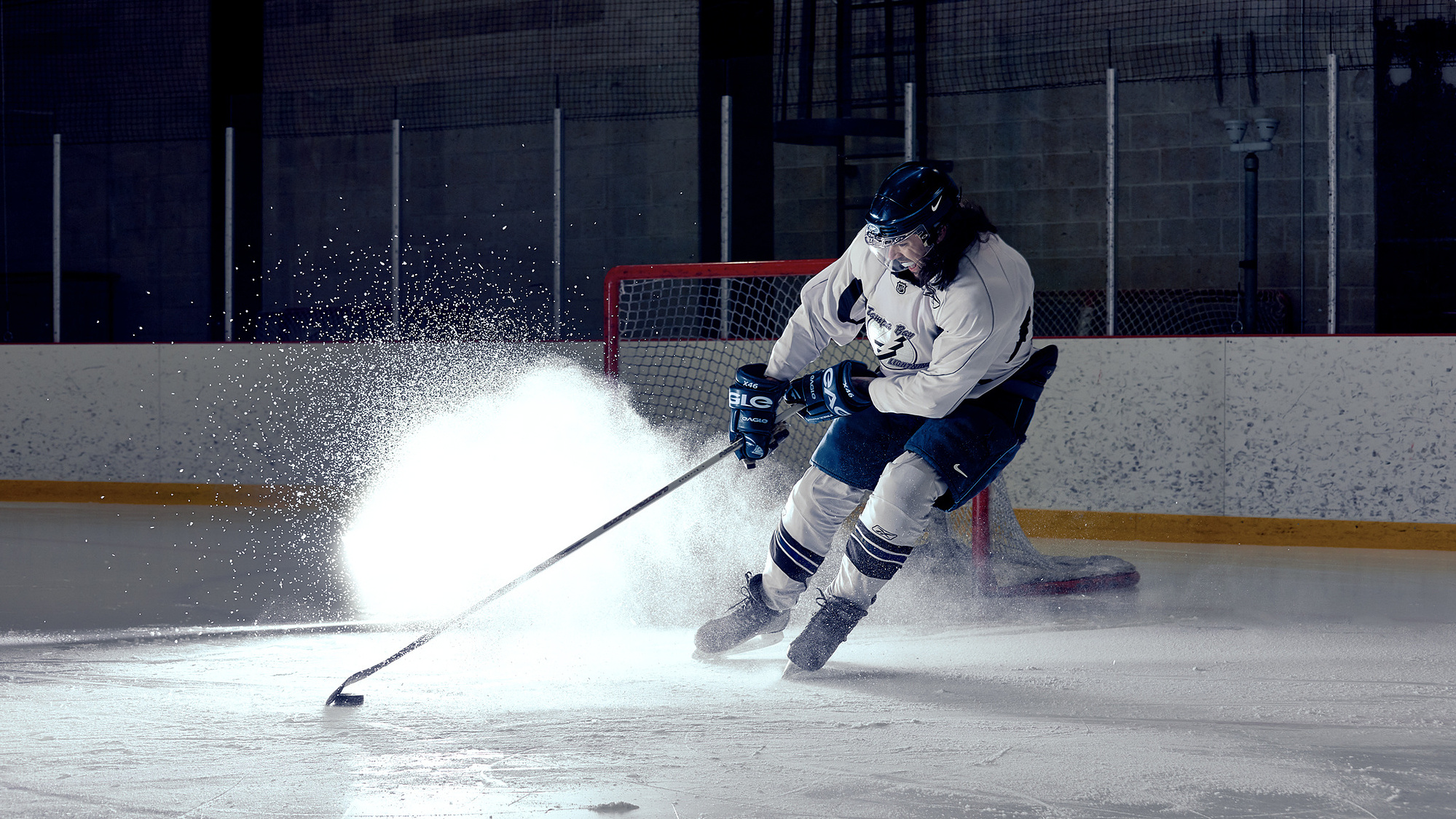 Hockey Player Breaking next to a goalie net