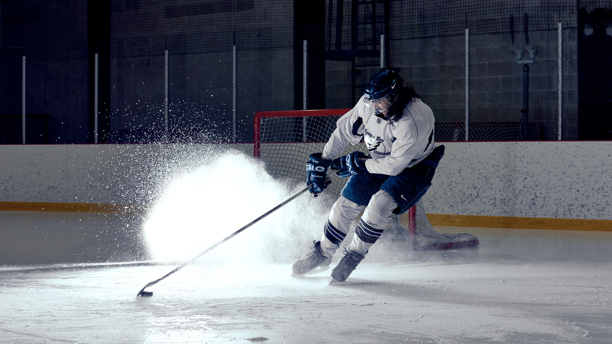 Hockey Player Breaking next to a goalie net