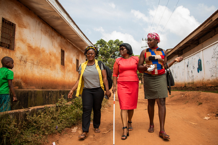 Eveline has set up a meeting with the mayor of the 7th district of Yaounde to discuss with him some project proposals. She is walking accompanied by her nice Odette and Quinta, a volunteer helper who comes to do some earrings for her from time to time.