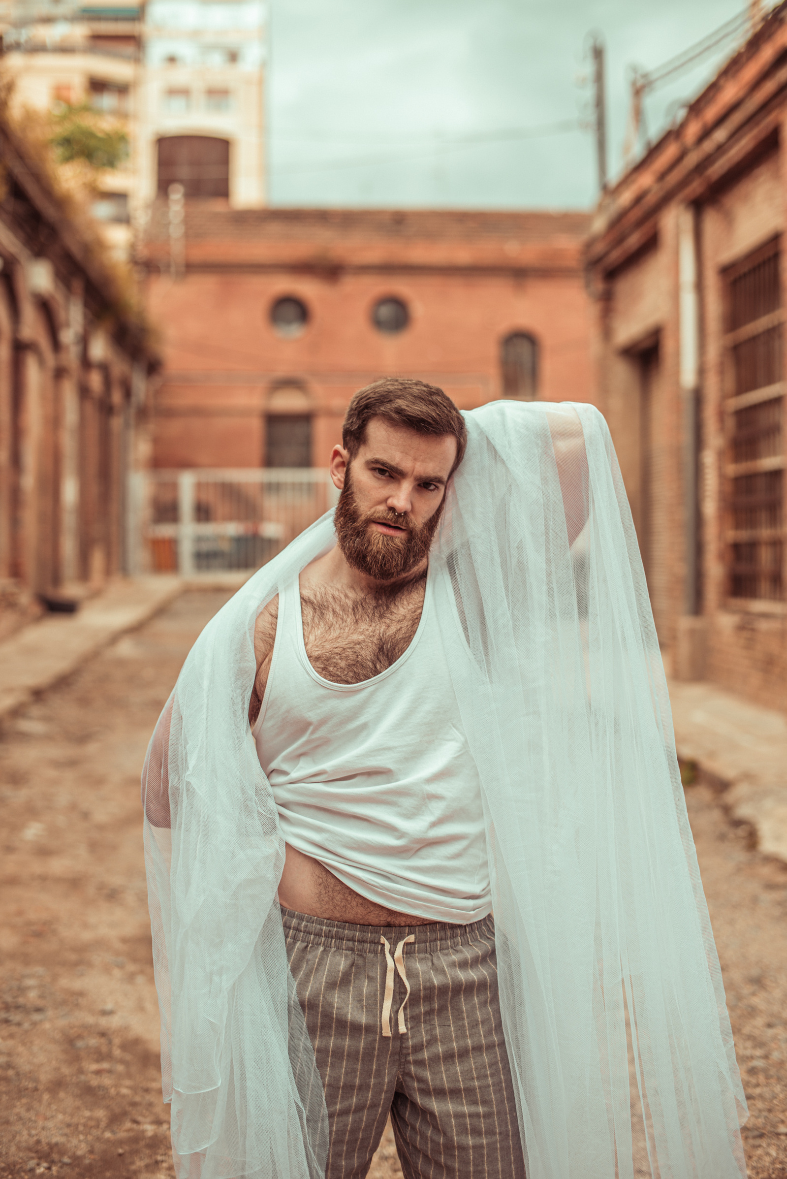 Model posing for a photoshoot with a white fabric