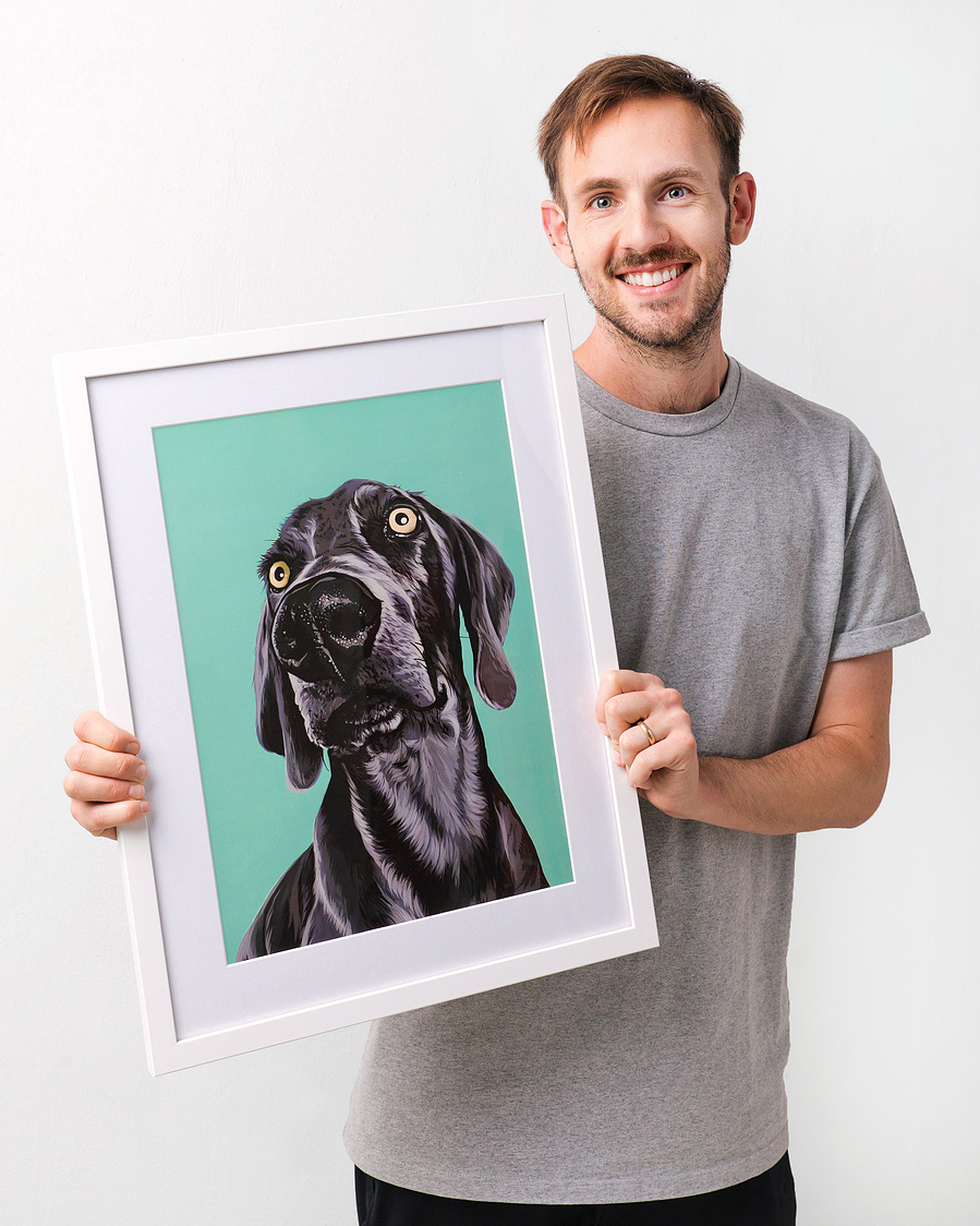Pet portrait artist Ryan Hodge is holding a framed portrait custom dog portrait of a Weimaraner. 
Woof Portraits 