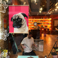 Ryan Hodge of Woof Portraits preparing the window display at Papersmiths for Chelsea Dog Day 2022.  
