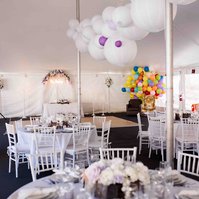 tented wedding with large white globes hanging and tables set for guests