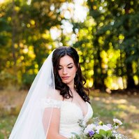 bride in wedding dress looking down holding flowers
