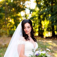 bride in wedding dress looking down holding flowers